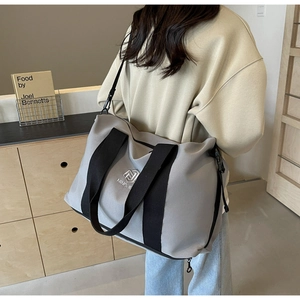 Détail du grand sac cabas gris clair avec poignées supérieures et bandoulière réglable