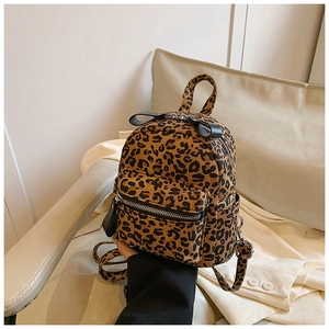 Close-up of leopard print mini backpack with black leather bow and silver zipper detail