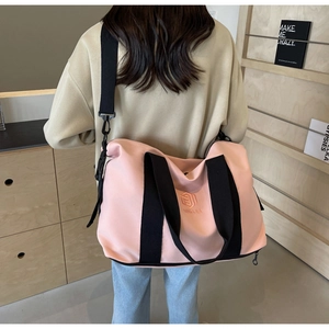 Vue arrière du grand sac de voyage rose montrant la taille et la sangle sur modèle