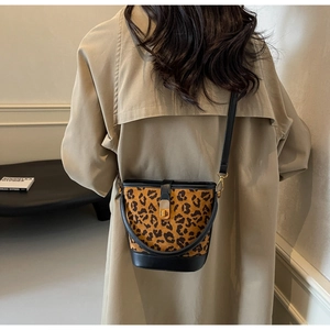 Detail der Leoparden-Beuteltasche mit schwarzem Lederbesatz und goldenem Verschluss