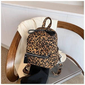 Detailed close-up of a mini leopard print backpack with corduroy texture on a chair