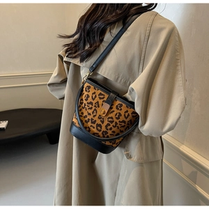 Dettaglio della borsa a secchiello leopardata con tracolla in pelle nera e chiusura in metallo