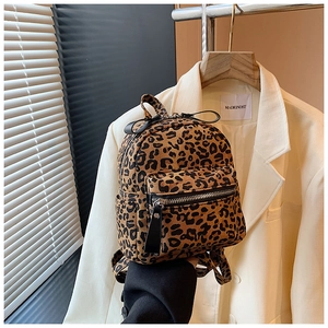 Close-up of leopard print backpack with front zipper pocket against a stylish blazer