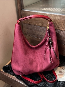 Minimalist burgundy suede hobo tote bag with braided tassel and gold zipper detail