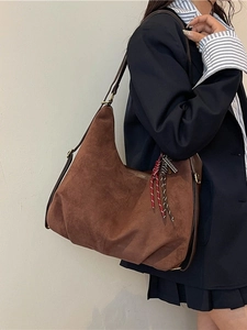 Brown frosted leather tote bag with braided rope detail worn with a navy blazer