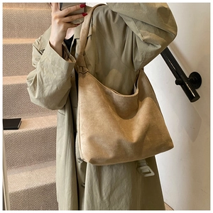 Close-up of minimalist khaki suede tote bag showing soft texture and wide shoulder strap