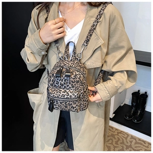 Close-up of leopard print mini backpack with adjustable strap on a female model