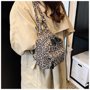 Close-up of leopard print mini backpack showing double zippers and adjustable straps