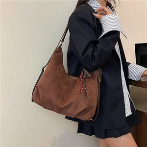 Brown suede hobo shoulder bag with colorful woven tassel charm for daily commute