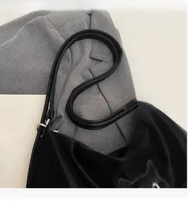 Détail du cabas en nylon noir avec écusson chat en peluche et longues anses fines