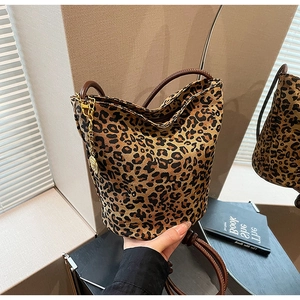 Detail of leopard print bucket bag with brown leather strap and gold chain accent