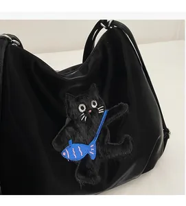 Détail du sac cabas noir avec broderie chat en peluche et motif de poisson bleu