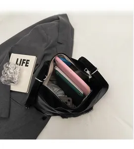 Gros plan de l'intérieur spacieux du cabas noir contenant une tablette et accessoires