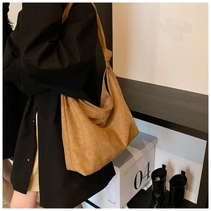 Close-up of brown suede hobo bag with a decorative knotted shoulder strap detail