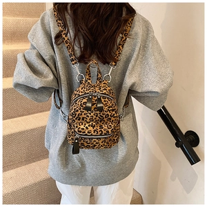 Detail view of mini leopard print backpack with silver metal hooks and sturdy fabric texture