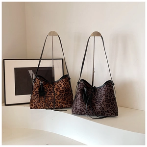 Macro detail of leopard print tote bags with texture and fringe drawstring accents