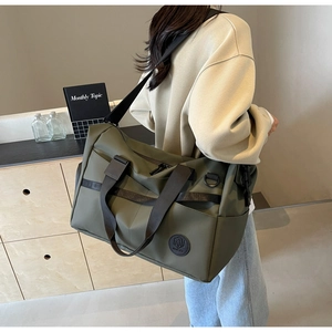 Dettaglio borsa da viaggio in nylon verde militare con tracolla regolabile e fibbia laterale