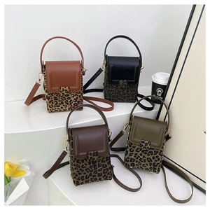 Detailed view of four leopard print vertical mini crossbody phone bags with top handles