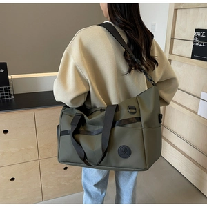 Dettaglio borsa da viaggio verde oliva con tracolla regolabile e tessuto in nylon