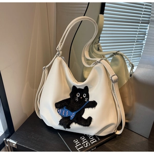 Détail du sac cabas en cuir blanc avec broderie de chat noir et petit accent de poisson bleu