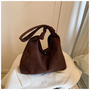 Detailed view of the brown suede hobo bag featuring a decorative knotted shoulder strap