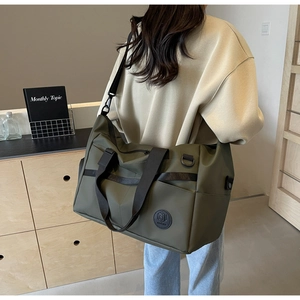 Vista posteriore di una modella con borsa da viaggio verde oliva e tracolla larga
