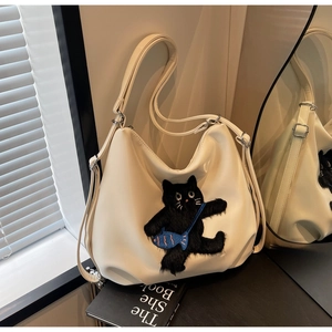Détail d'un sac cabas blanc crème avec motif chat noir en peluche et large bandoulière