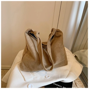 Detail of khaki suede tote bag featuring a stylish knotted shoulder strap and soft texture