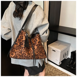 Detail shot of the spacious leopard print tote bag with black leather straps and fashion tag