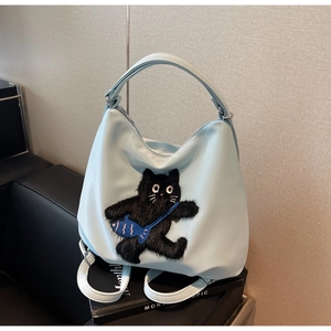 Détail du cabas en nylon bleu clair avec broderie chat noir en 3D et petit sac poisson