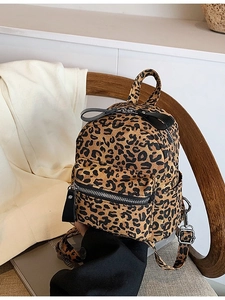Chic leopard print mini backpack for travel with dual compartments on wooden chair