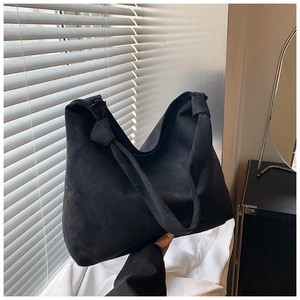 Detail of vintage matte black tote bag showing the unique knotted shoulder strap design