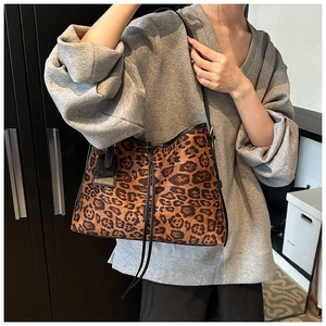 Detail view of large leopard print tote bag with black drawstring and fashion hangtag