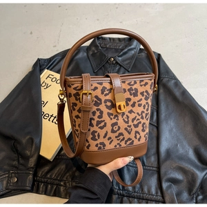 Dettaglio della borsa a secchiello leopardata con finiture in pelle marrone e fibbia