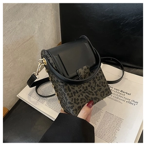 Detail of leopard print crossbody phone bag with gold studs and black leather flap