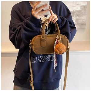 Dettaglio mini borsa Boston in camoscio marrone con ciondolo orsetto e cerniere dorate