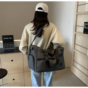 Dettaglio borsa da viaggio grigia in nylon impermeabile con tracolla regolabile e logo