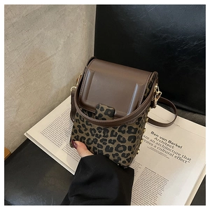 Close-up of leopard print canvas and brown leather flap on a mini crossbody phone bag