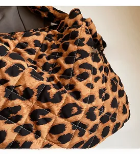 Gros plan détaillé du tissu matelassé imprimé léopard montrant texture et coutures