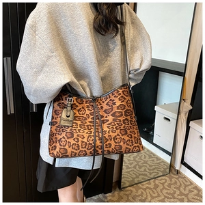 Detail of leopard print tote bag with drawstring closure and black leather tag