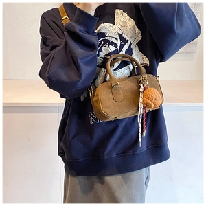 Dettaglio borsa bowling vintage in pelle scamosciata con ciondolo a cucciolo