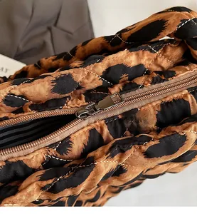 Détail macro du sac matelassé à imprimé léopard avec fermeture éclair et doublure rayée