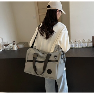 Borsa da viaggio grigia in nylon resistente con tracolla regolabile mostrata in uso
