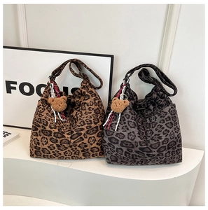 Detail of leopard print canvas tote bags with drawstring closure and plush bear charms