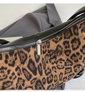 Dettaglio della cerniera in metallo e del tessuto felpato con stampa leopardata