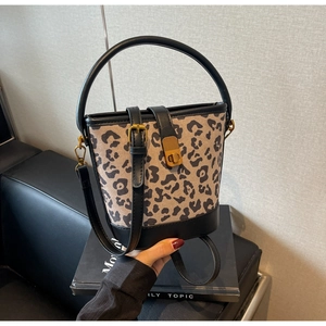 Detailansicht der Leopard-Eimertasche mit Goldschnalle und schwarzen Lederbesatz-Details