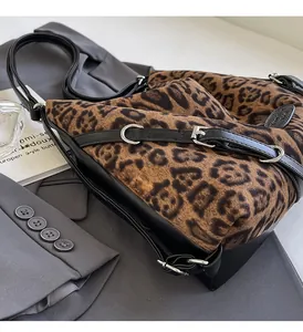 Dettaglio della borsa tote leopardata con tracolla in pelle nera e fibbie in metallo argento
