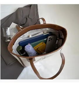 Close-up of a large canvas tote bag showing the interior zipper pocket and spacious capacity