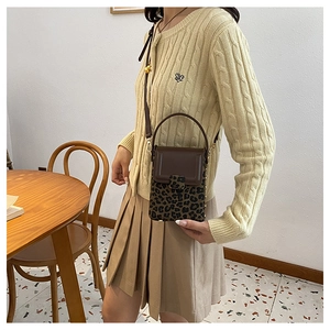 Detail view of mini crossbody phone bag with vintage leopard print and brown leather