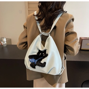 Détail d'un sac cabas décontracté avec broderie chat en peluche et pendentif petit poisson